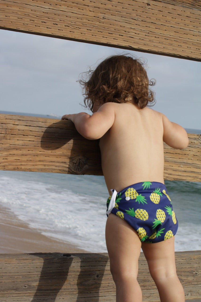 baby at the beach wearing Beau and Belle Littles Swim Diaper, Regular Size, Navy blue with pineapples