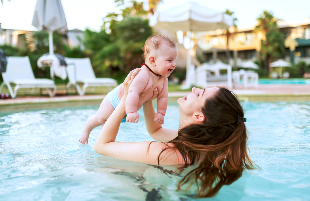 Mother lifting her baby in the pool