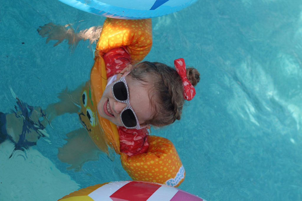 a child swimming with her flamingo outfit