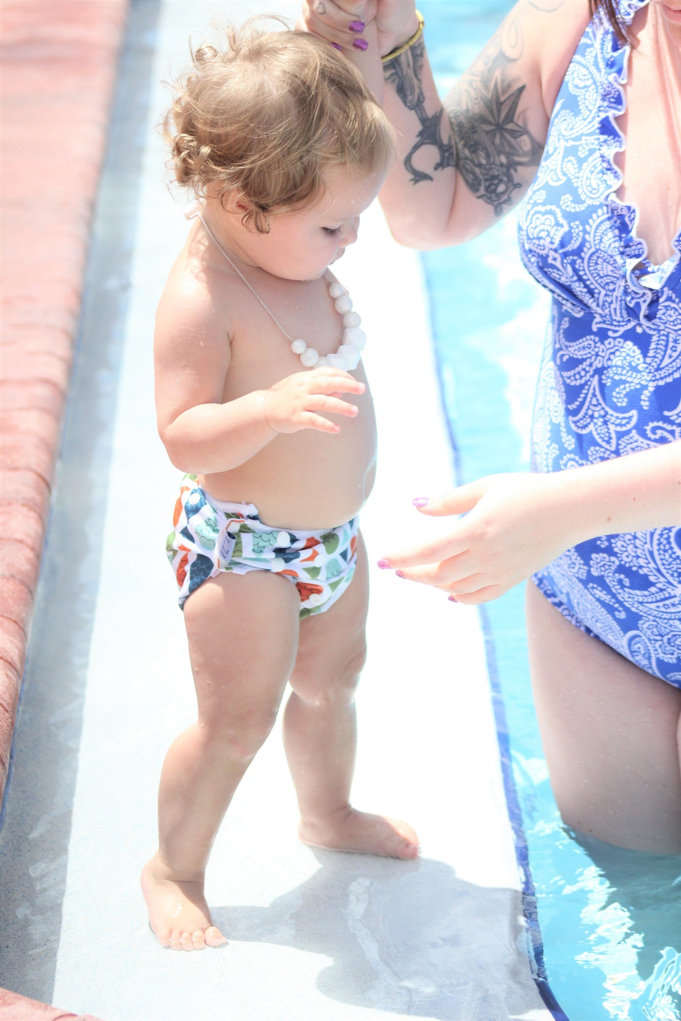 little girl standing on the step of a pool wearing a Beau and Belle Littles Swim Diaper, Regular Size, fish print