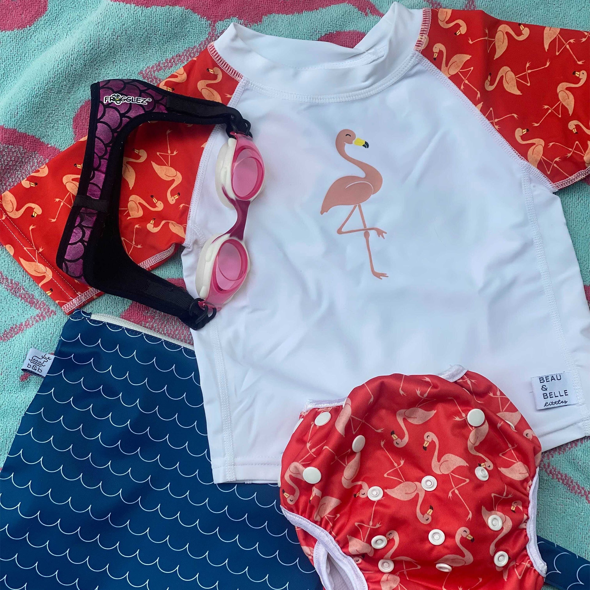 swimming starter kit for girls with pink Frogglez Goggles, a blue waves wet bag, flamingo swim bottom with a diaper included, and a matching swim shirt