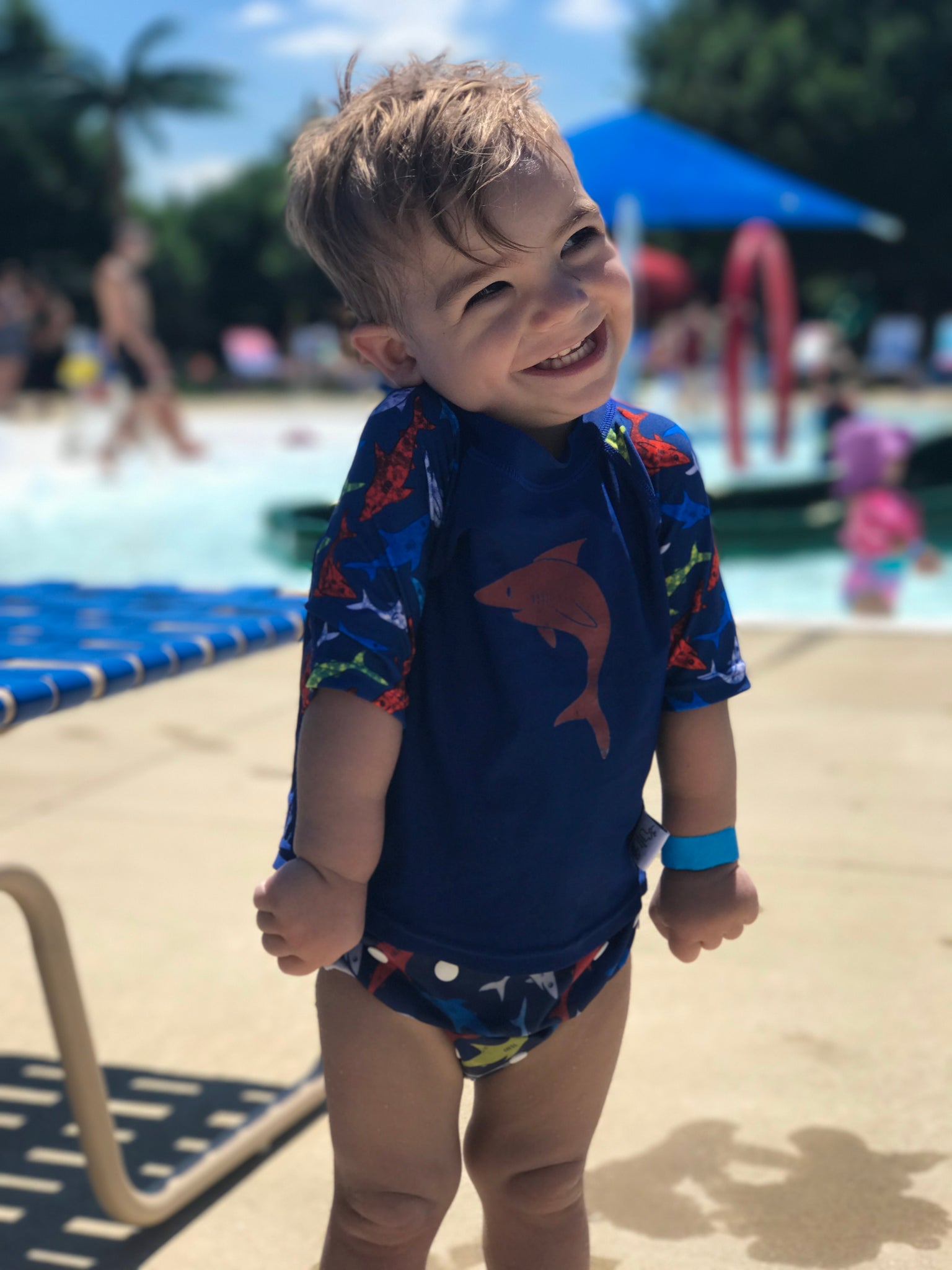 boy wearing a Beau and Belle Littles Rash Guard/Swim Shirt, dark blue with lighter blue 3/4 sleeves, shark print and matching swim diaper