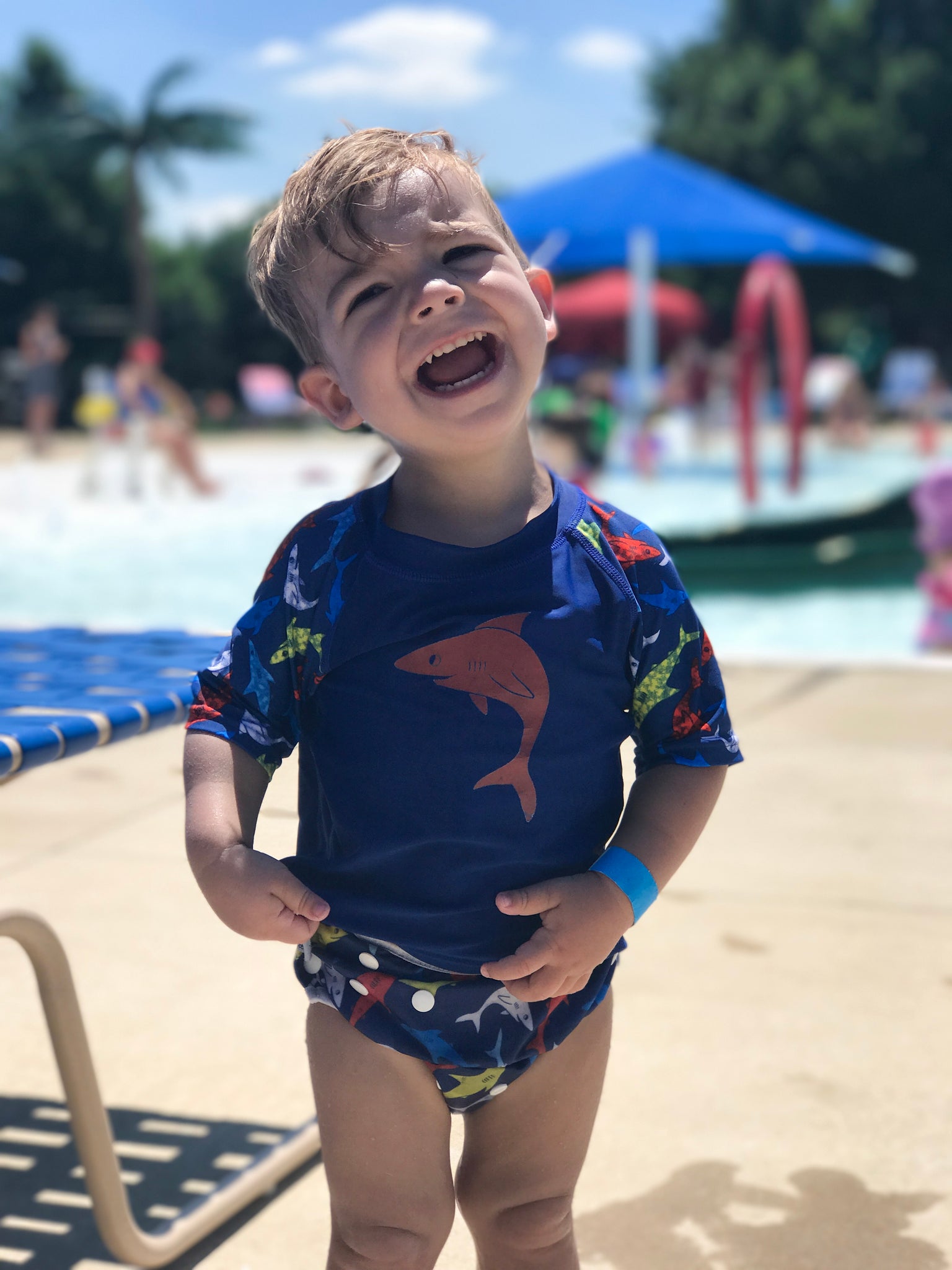 boy wearing a Beau and Belle Littles Rash Guard/Swim Shirt, dark blue with lighter blue 3/4 sleeves, shark print and matching swim diaper