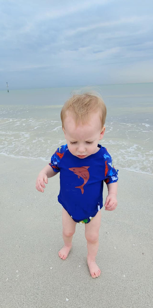 baby boy wearing a Beau and Belle Littles Rash Guard/Swim Shirt, dark blue with lighter blue 3/4 sleeves, shark print